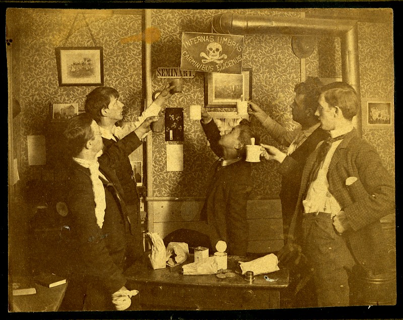 Another 1890 image. The students appear to be toasting with shaving mugs. The Latin inscription is from Tacitus: "We raise the dead by magical incantations." Such is the benefit of a classical education.