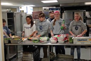Members of the Community Service Club prepare food at Kate's Kitchen, which serves neighbors in need.